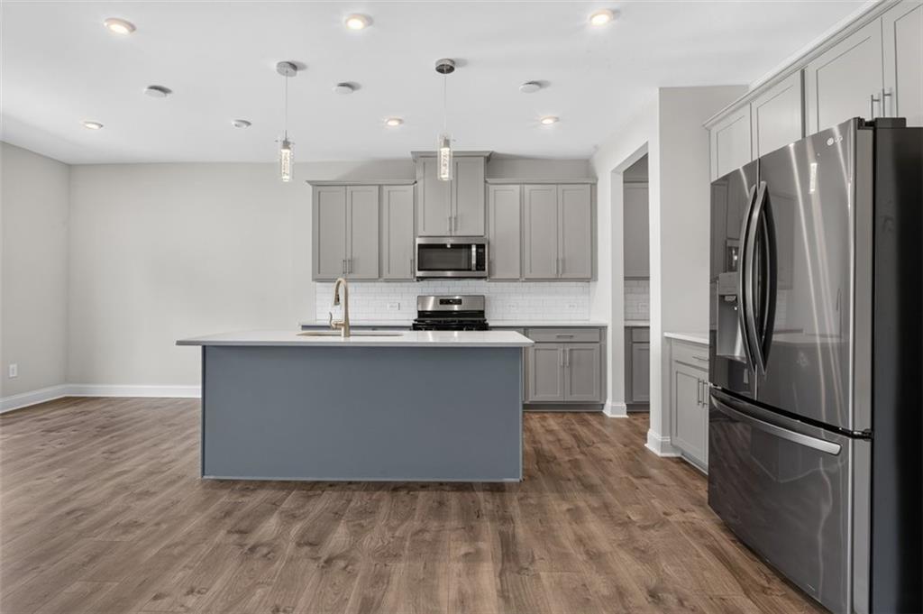 107 Ledgemont Way Acworth, GA 30101 - Photo 11 of 57 a kitchen with kitchen island a refrigerator and a stove top oven