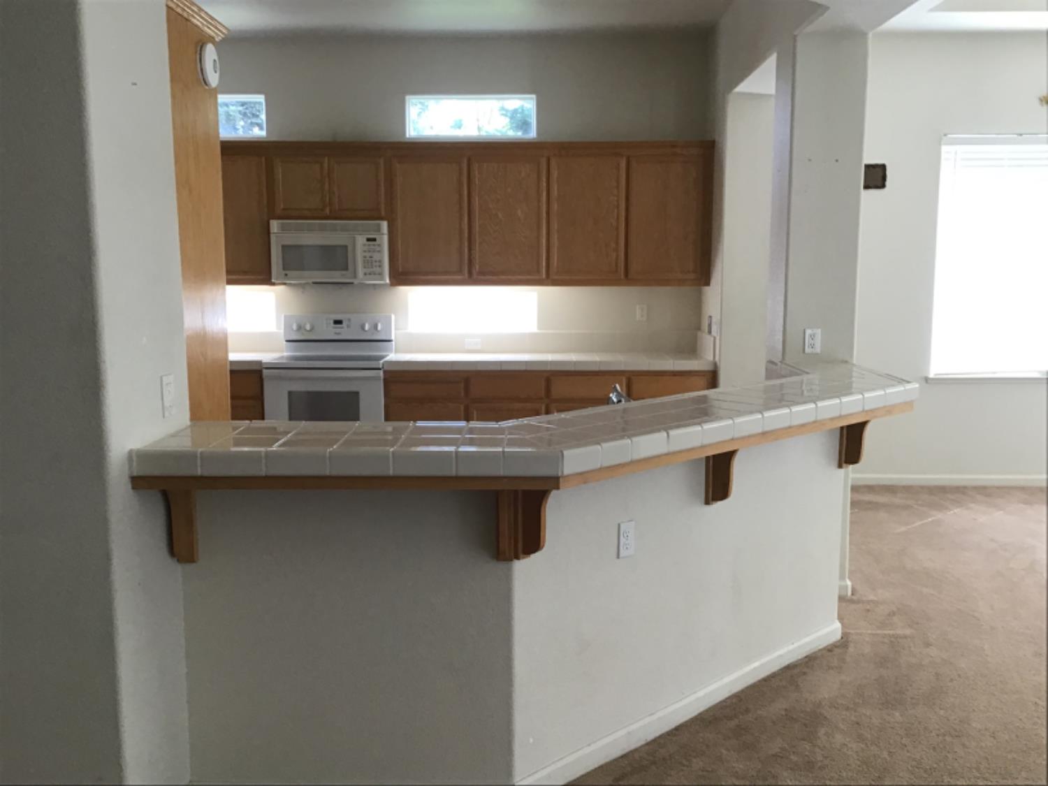 205 Quail Meadow Lane Copperopolis, CA 95228 - Photo 13 of 27 a kitchen with stainless steel appliances a sink stove and cabinets