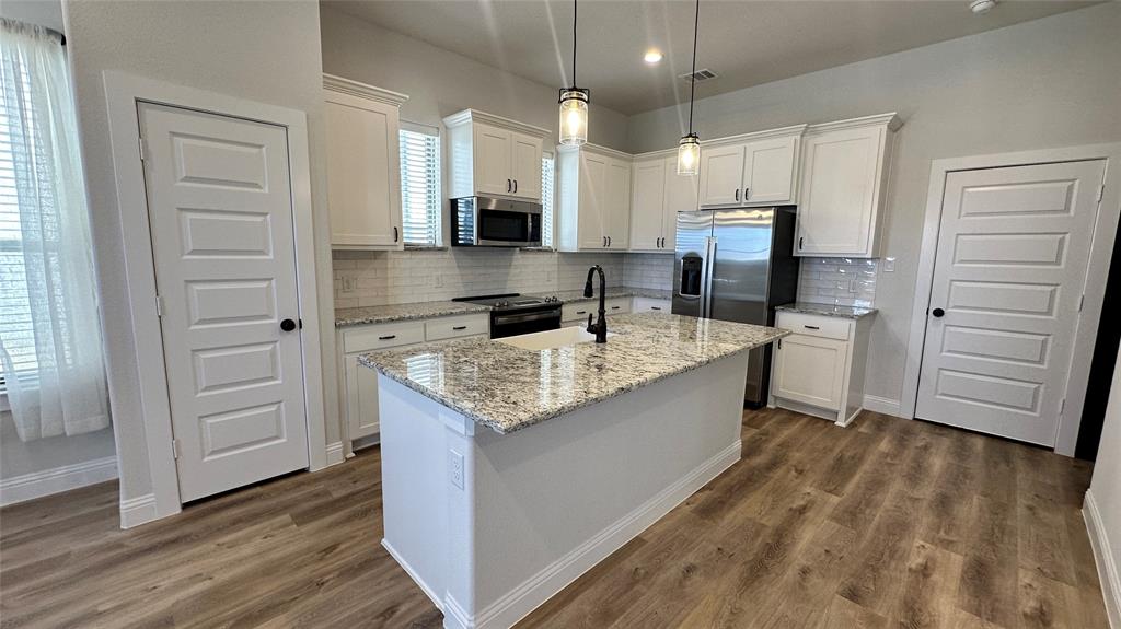 4100 Avion Drive Sanger, TX 76266 - Photo 1 of 1 a large kitchen with a stove oven and wooden floor