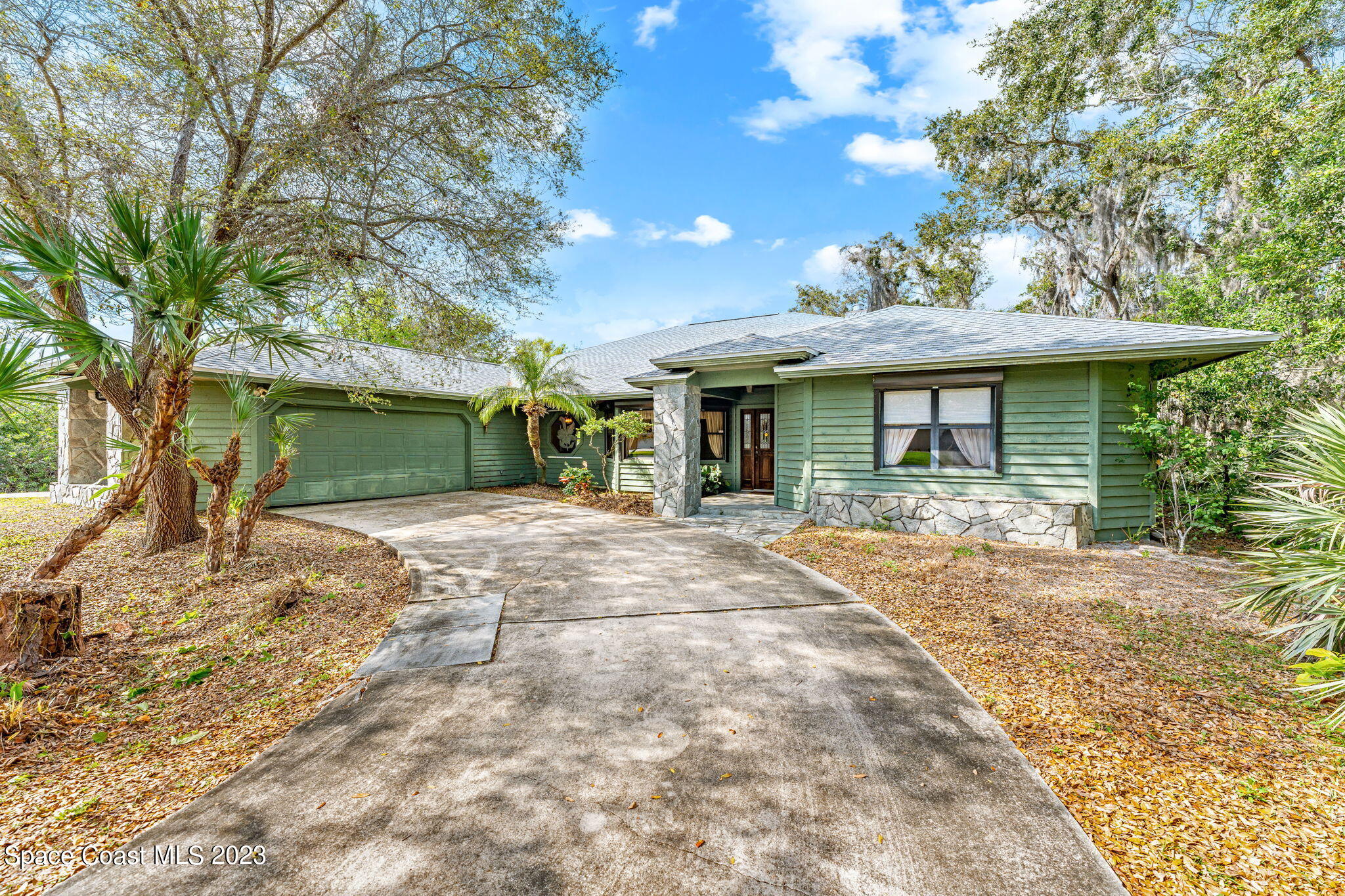 a view of a house with a yard and large tree