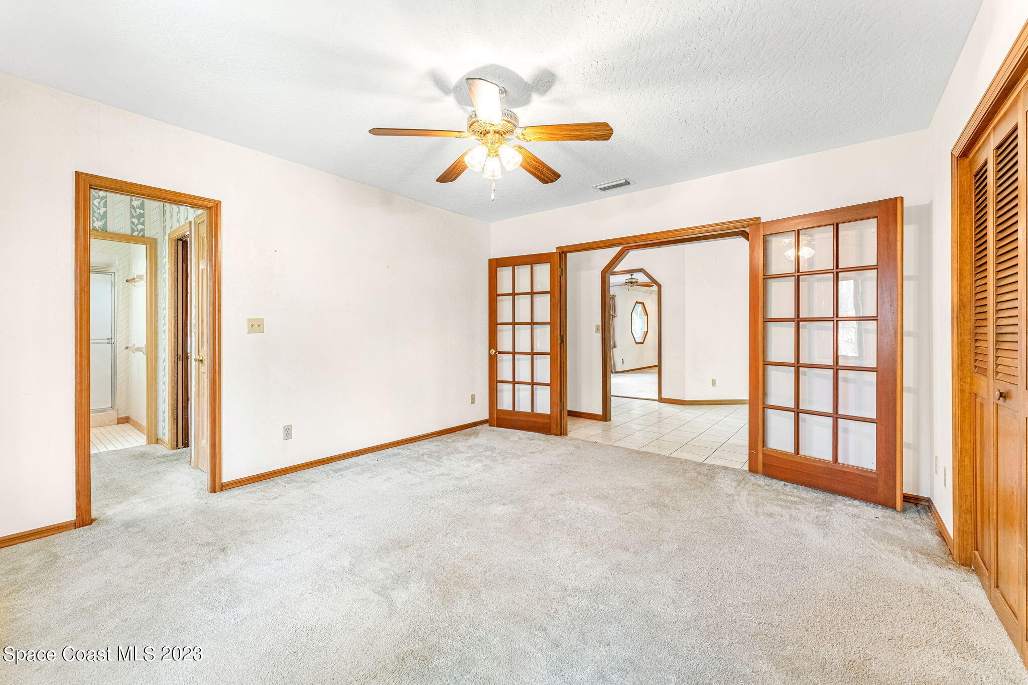 3700 Shady Run Road Melbourne, FL 32934 - Photo 12 of 27 an empty room with windows and ceiling fan