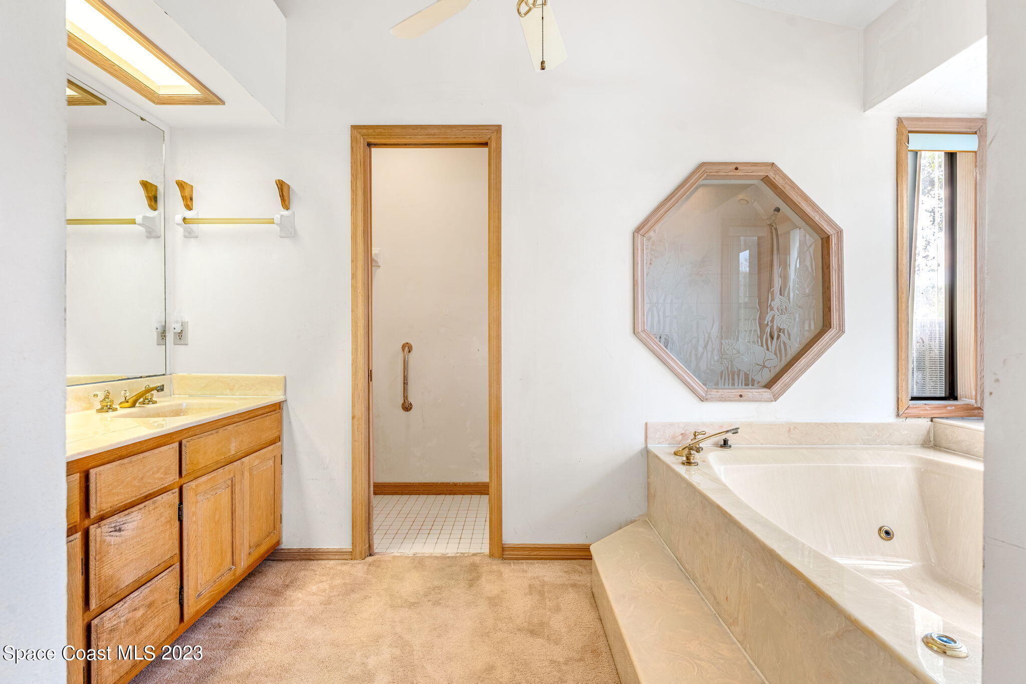 3700 Shady Run Road Melbourne, FL 32934 - Photo 10 of 27 a bathroom with a tub sink and mirror