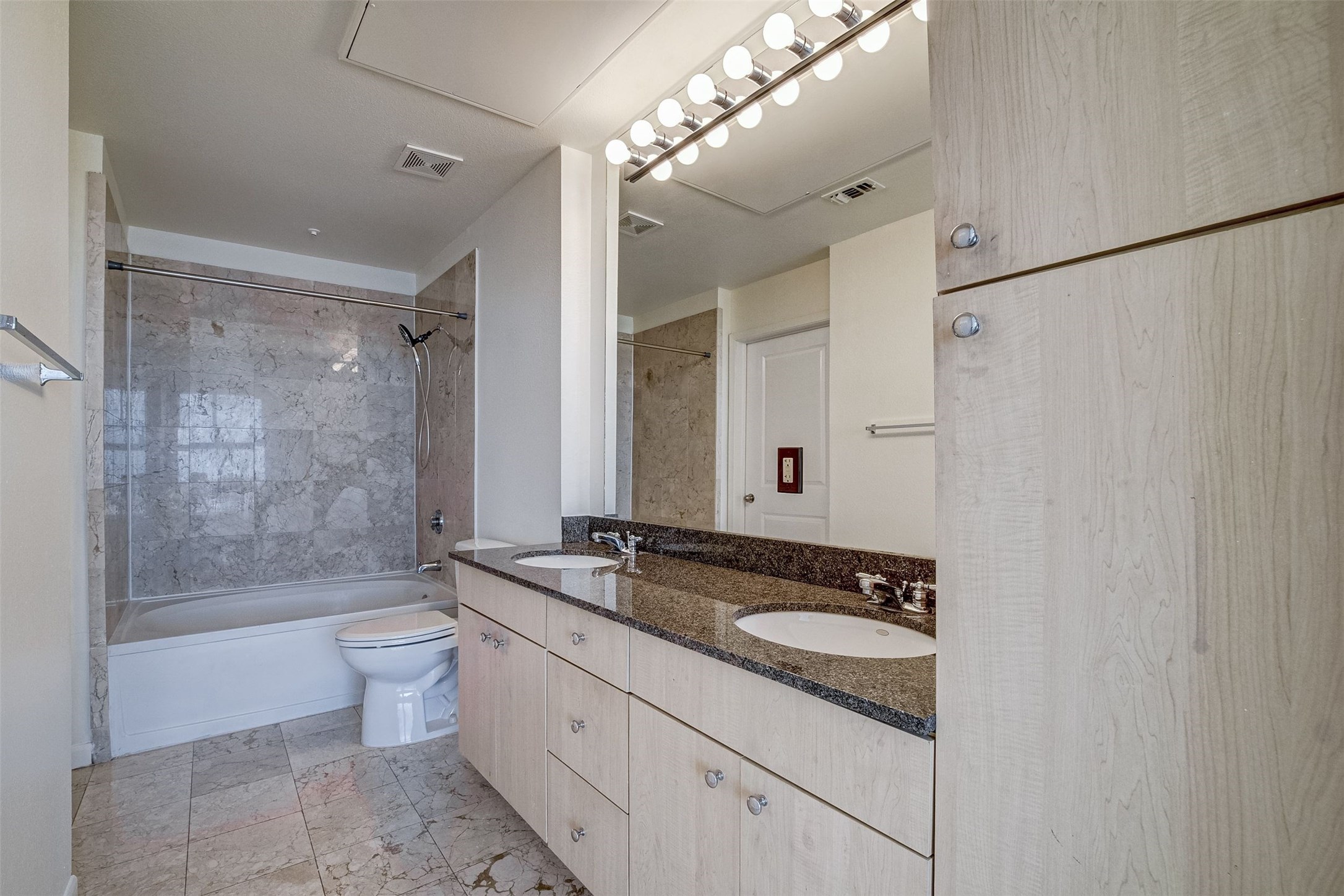 3505 Sage Road, Unit 2403 Houston, TX 77056 - Photo 21 of 26 a bathroom with a granite countertop sink a toilet a mirror and bathtub