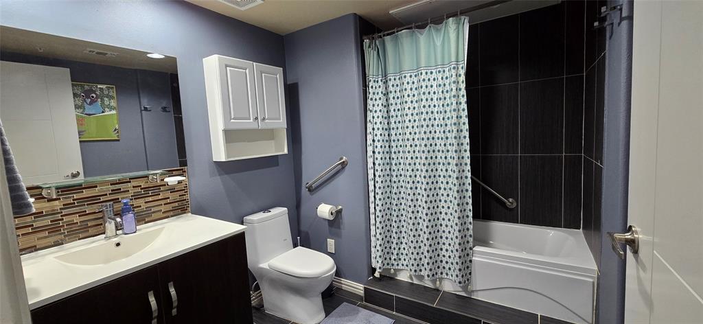 1100 West Trinity Mills Road, Unit 2045 Carrollton, TX 75006 - Photo 11 of 20 Full bath featuring vanity, shower / bathtub combination with curtain, and tasteful backsplash
