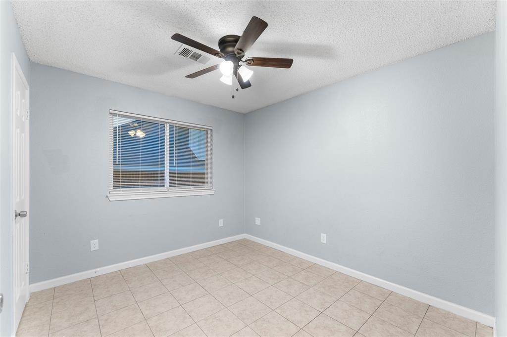 1042 Kim Lane Mesquite, TX 75149 - Photo 11 of 16 an empty room with a chandelier fan and windows