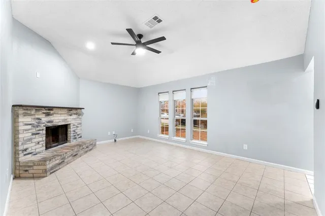 a view of an empty room with a fireplace and a window