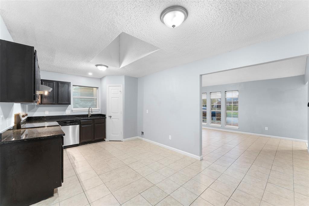 1042 Kim Lane Mesquite, TX 75149 - Photo 5 of 16 a kitchen with stainless steel appliances granite countertop a stove top oven a sink a counter space and cabinets