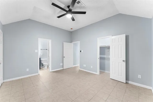 an empty room with closet and a ceiling fan