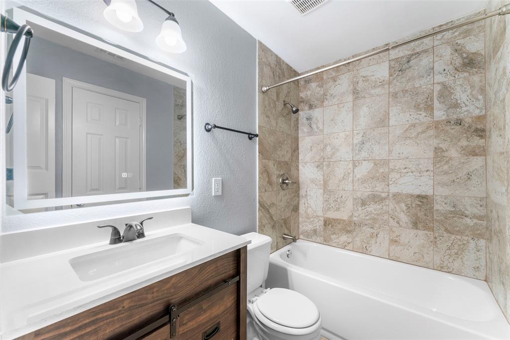 1042 Kim Lane Mesquite, TX 75149 - Photo 9 of 16 a bathroom with a granite countertop bathtub shower sink vanity and toilet