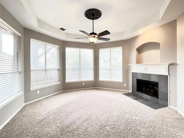 a view of an empty room with a fireplace and a window