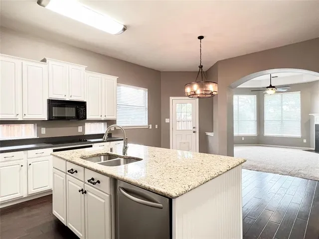 a kitchen with stainless steel appliances granite countertop a sink stove and white cabinets