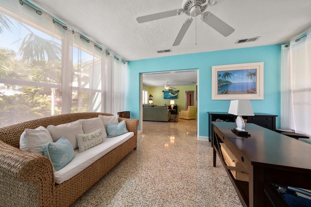 301 Cevera Road Dunedin, FL 34698 - Photo 12 of 33 a living room with furniture a desk and a chandelier