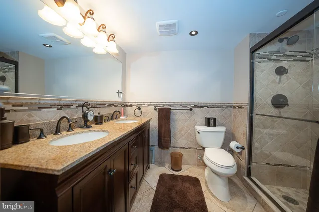 a bathroom with a granite countertop sink a toilet and a mirror