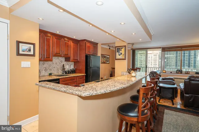 a kitchen with stainless steel appliances granite countertop a sink and a refrigerator