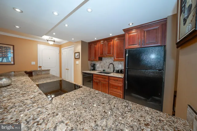 a kitchen with stainless steel appliances granite countertop a refrigerator sink and cabinets