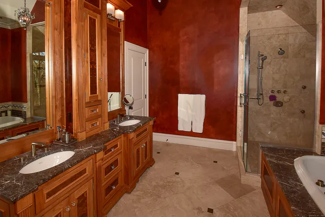 a bathroom with a double vanity sink a toilet a mirror and shower