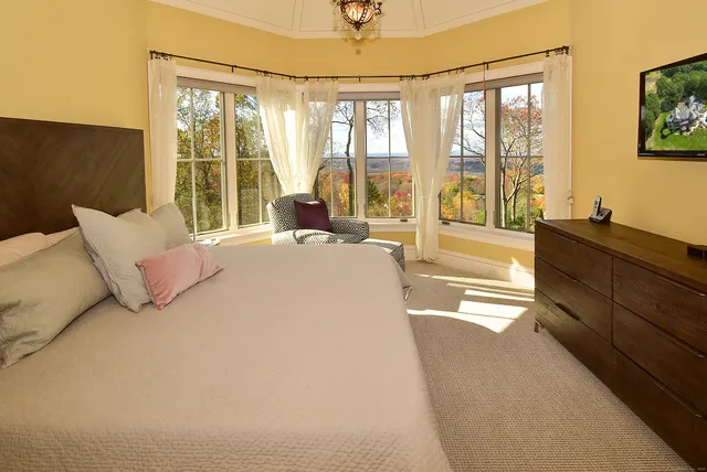 a spacious bedroom with a large bed and a large window