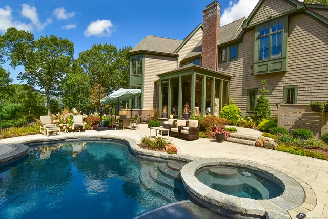 a view of a house with pool and chairs