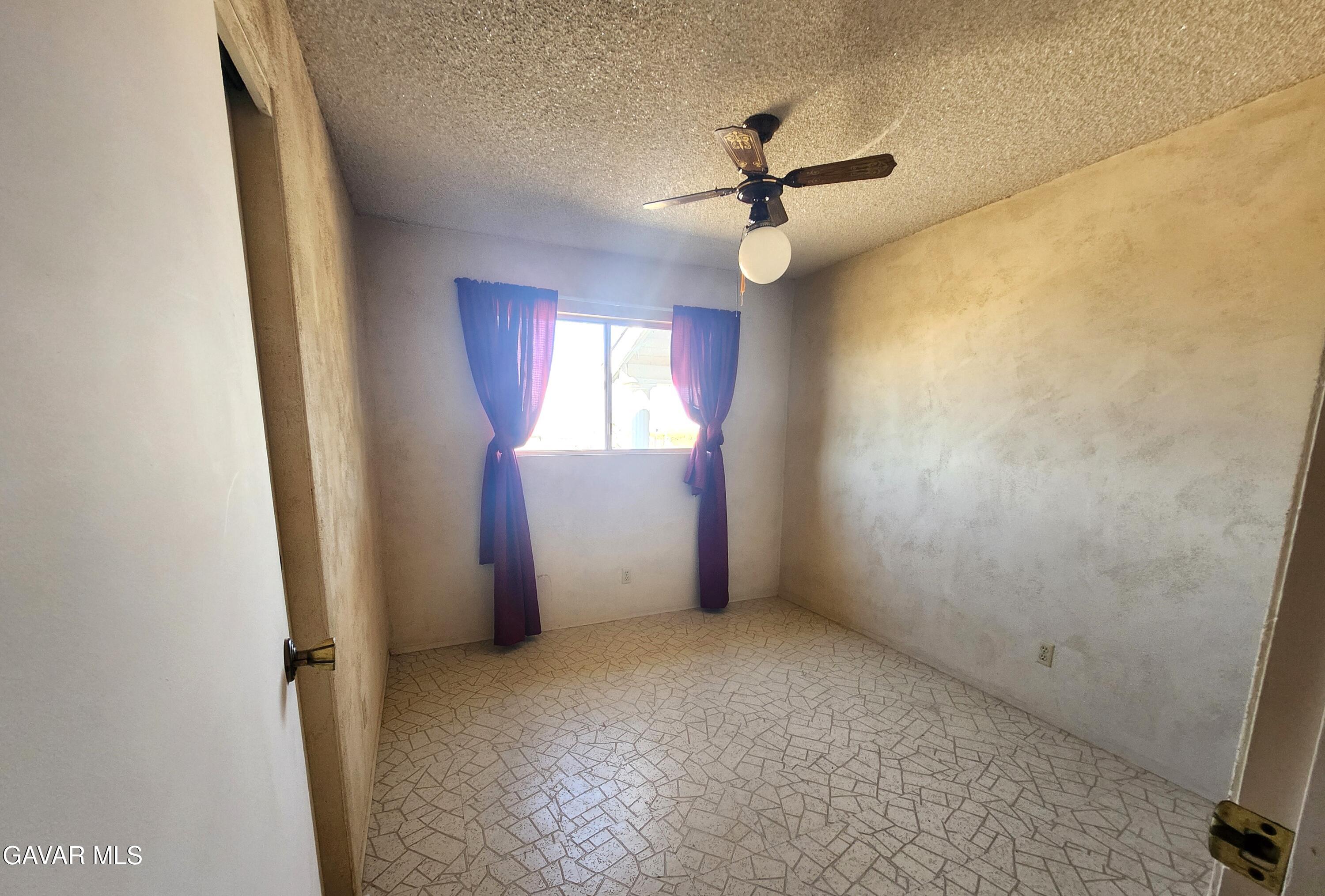 1407 West Burns Avenue Ridgecrest, CA 93555 - Photo 15 of 25 an empty room with windows and fan