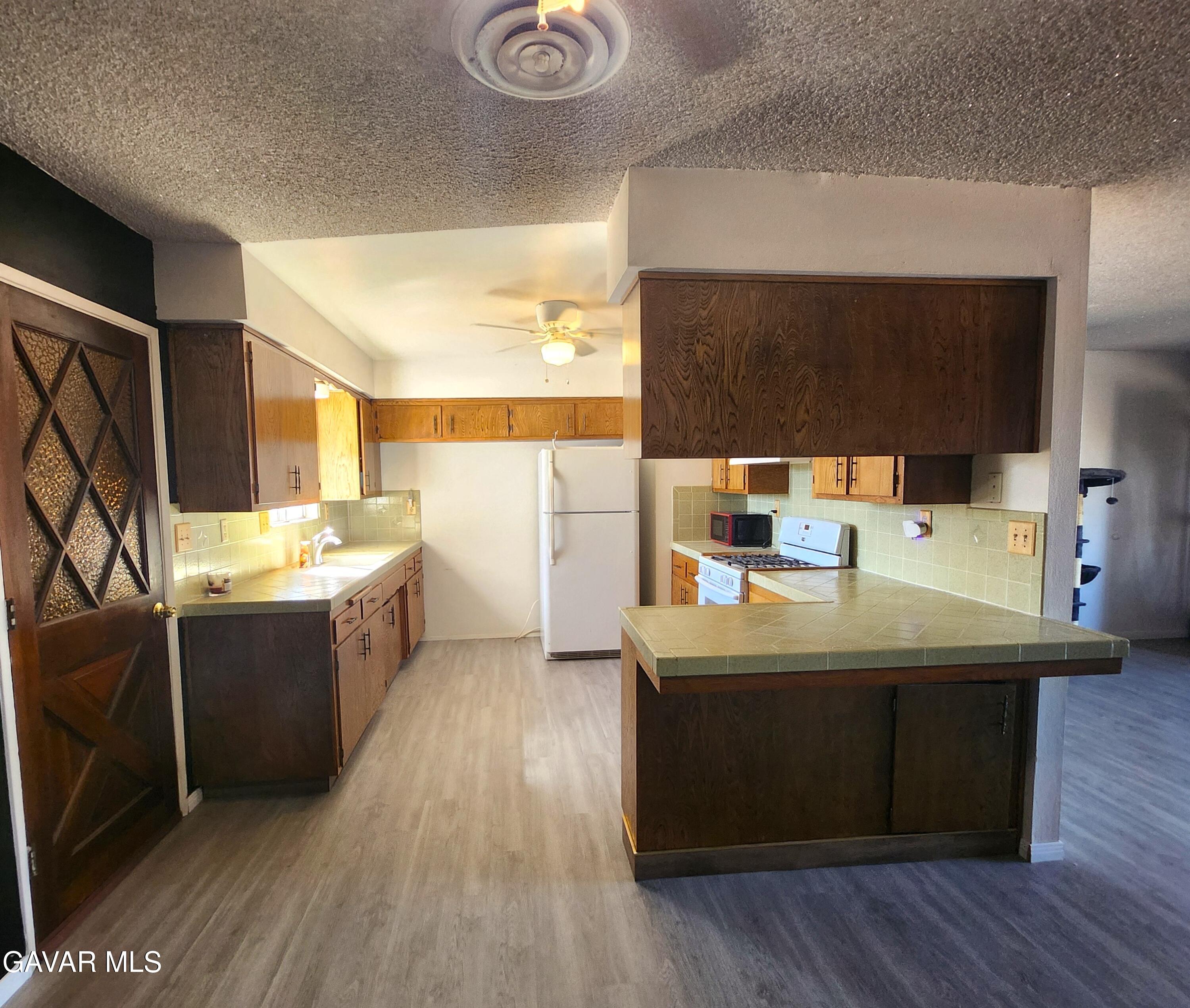 1407 West Burns Avenue Ridgecrest, CA 93555 - Photo 7 of 25 a kitchen with a sink cabinets and wooden floor