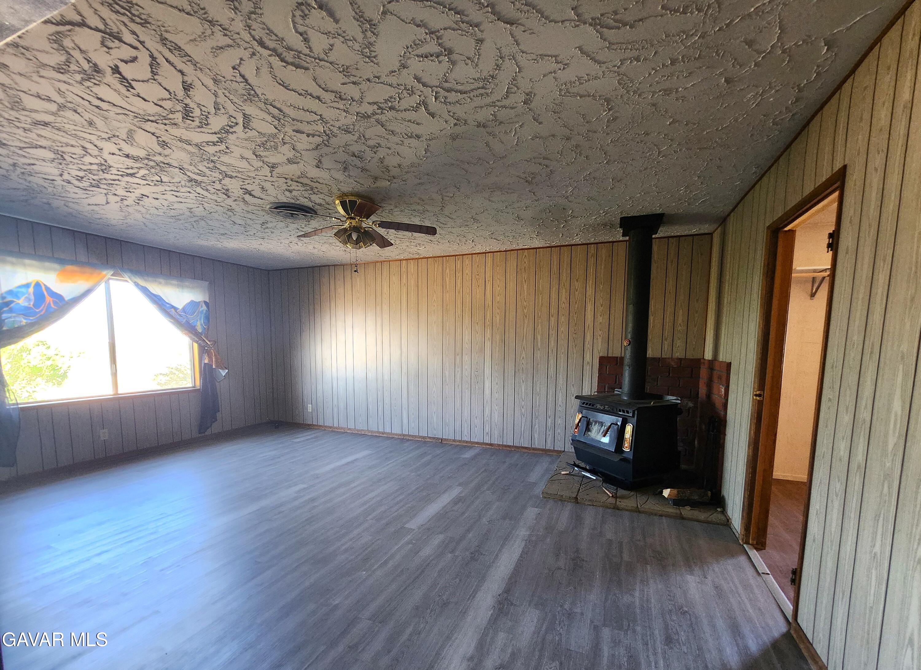 1407 West Burns Avenue Ridgecrest, CA 93555 - Photo 10 of 25 an empty room with wooden floor and windows
