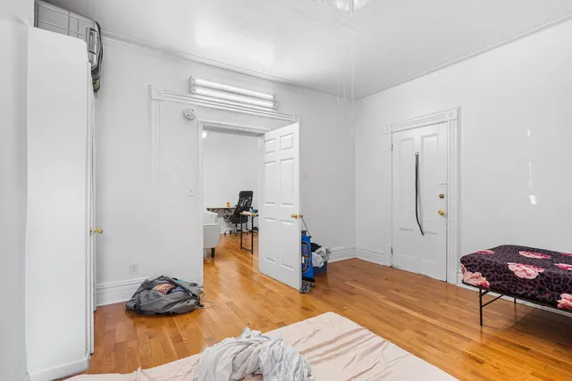 a bedroom with bed and wooden floor