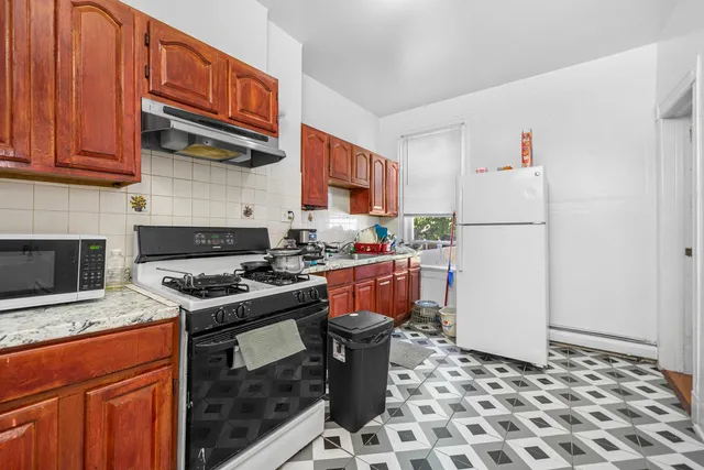 a kitchen with stainless steel appliances granite countertop a stove a refrigerator and a cabinets