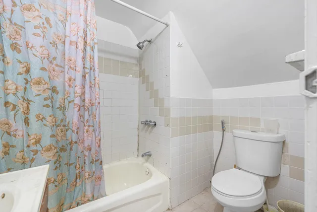 a white toilet sitting next to a bath tub