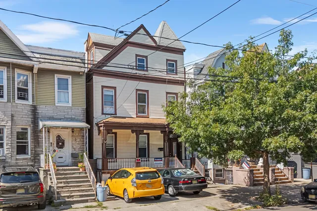 a front view of a house with a garden and balcony