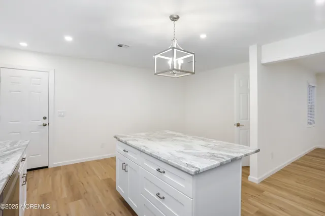 a kitchen with a granite countertop sink and refrigerator