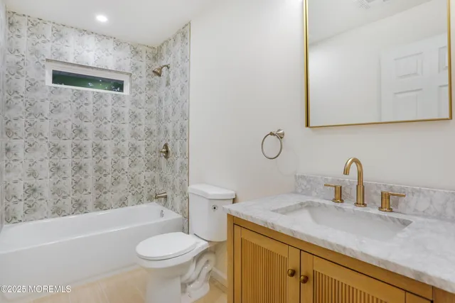 a bathroom with a sink toilet vanity granite shower and bathtub