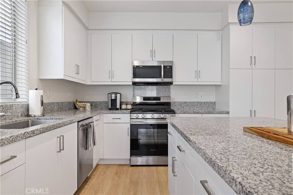 80138 Whisper Rock Way La Quinta, CA 92253 - Photo 13 of 29 a kitchen with granite countertop a sink stainless steel appliances and white cabinets