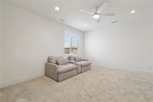 an empty room with windows and ceiling fan