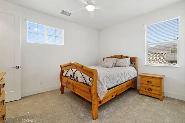 a bedroom with a bed and a lamp on the dresser
