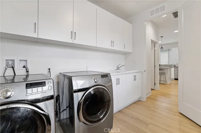 a view of a kitchen with stainless steel appliances granite countertop a sink and cabinets