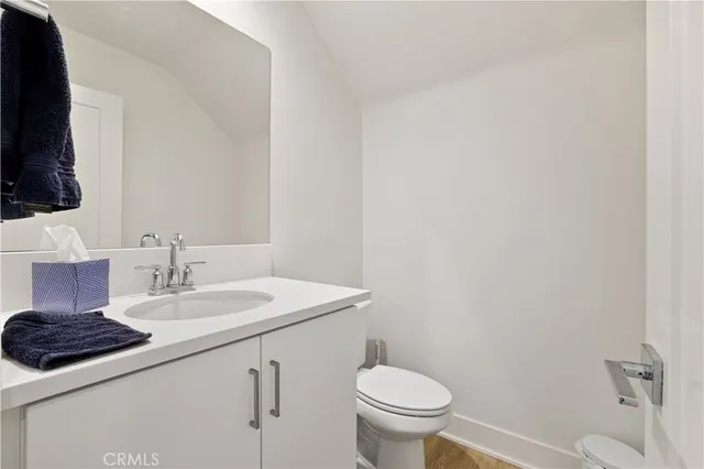 a bathroom with a sink a toilet a mirror and vanity