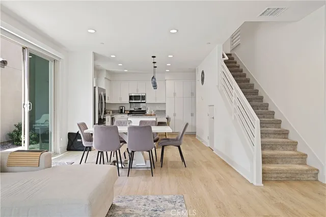 a dining room with furniture entryway and wooden floor