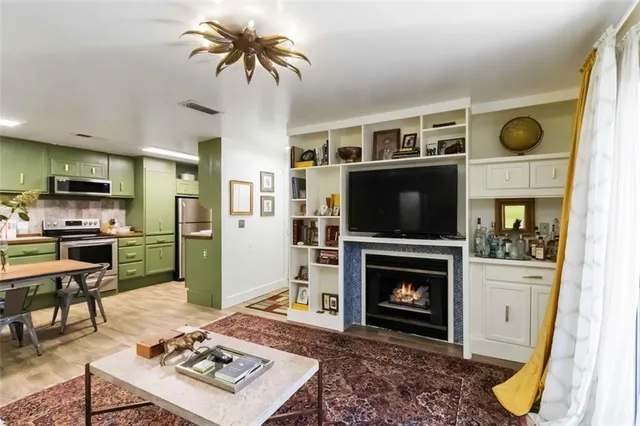 a living room with furniture a flat screen tv and a fireplace