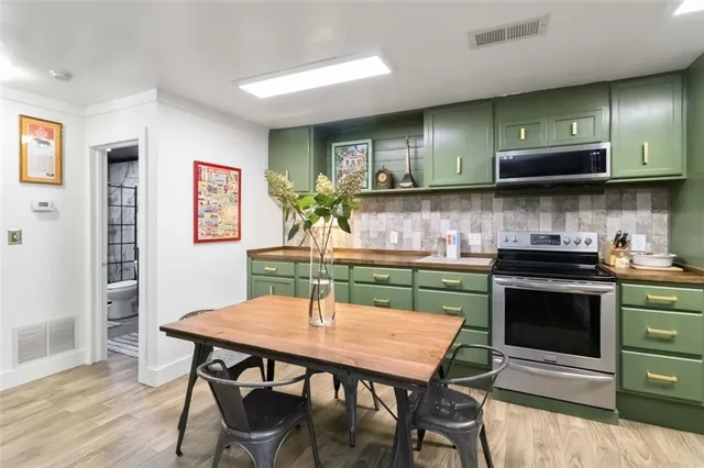 a kitchen with stainless steel appliances granite countertop a stove top oven a sink dishwasher and cabinets with wooden floor