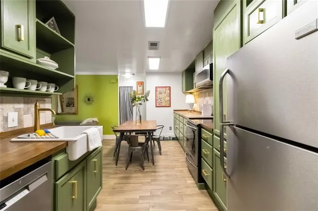 a kitchen with stainless steel appliances granite countertop a refrigerator a stove and a dining table