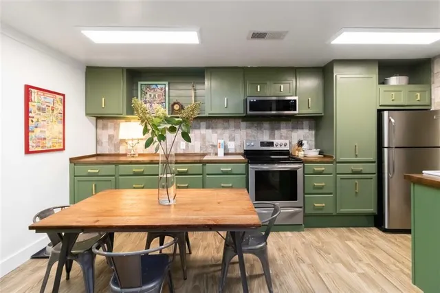 a kitchen with a table chairs refrigerator and microwave
