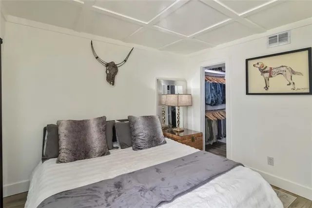 a bedroom with a bed and painting on the wall