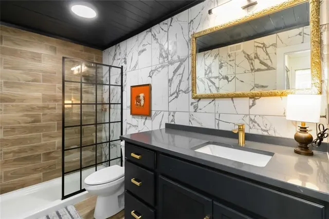 a bathroom with a sink a toilet and shower