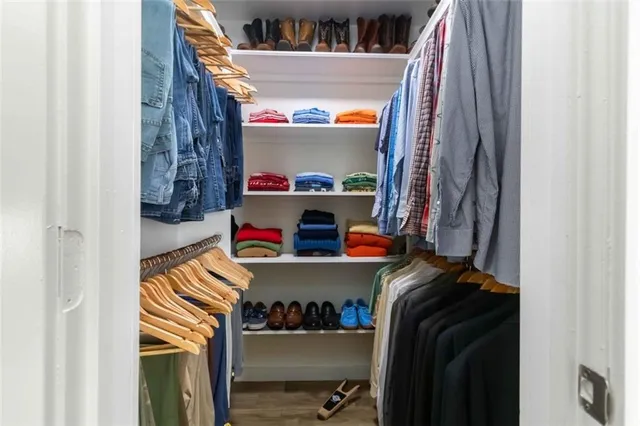 a view of walk in closet with clothes and shoes