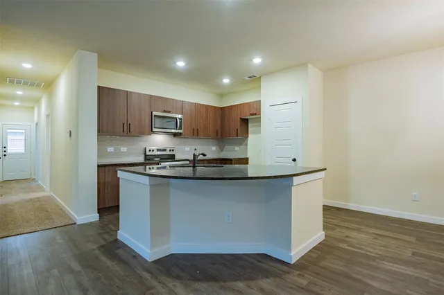 a kitchen with stainless steel appliances granite countertop a stove a sink and a refrigerator