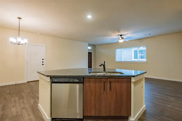 a kitchen with granite countertop a sink and cabinets