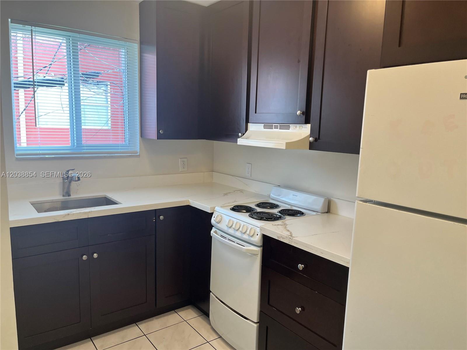 1419 Southwest 22nd Avenue Miami, FL 33145 - Photo 8 of 20 a kitchen with a sink a stove and a refrigerator