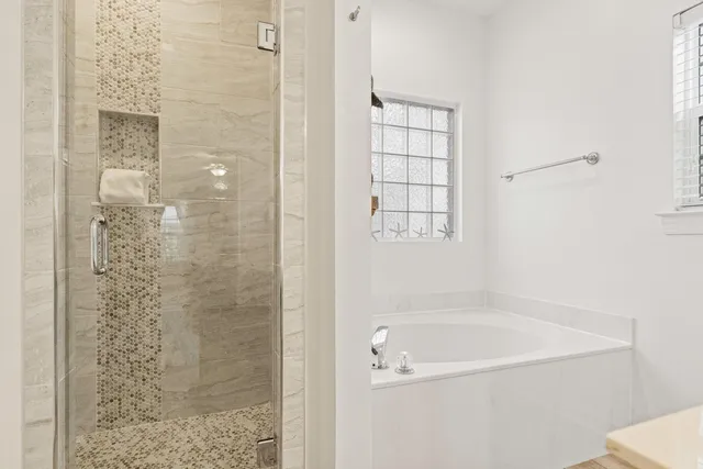 a white bath tub sitting next to a shower