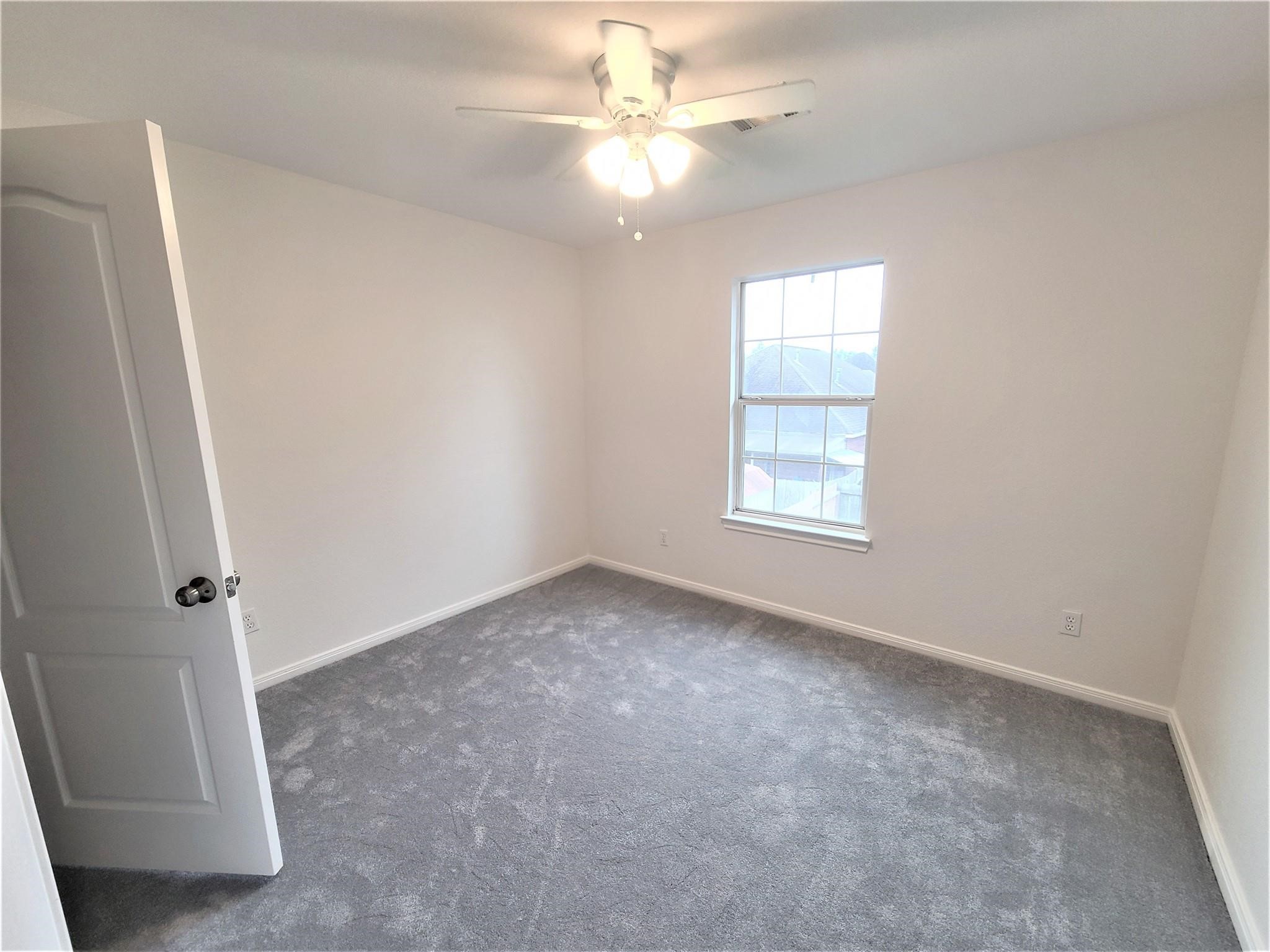 10026 Gil Jr Lane Houston, TX 77075 - Photo 11 of 14 an empty room with windows and fan