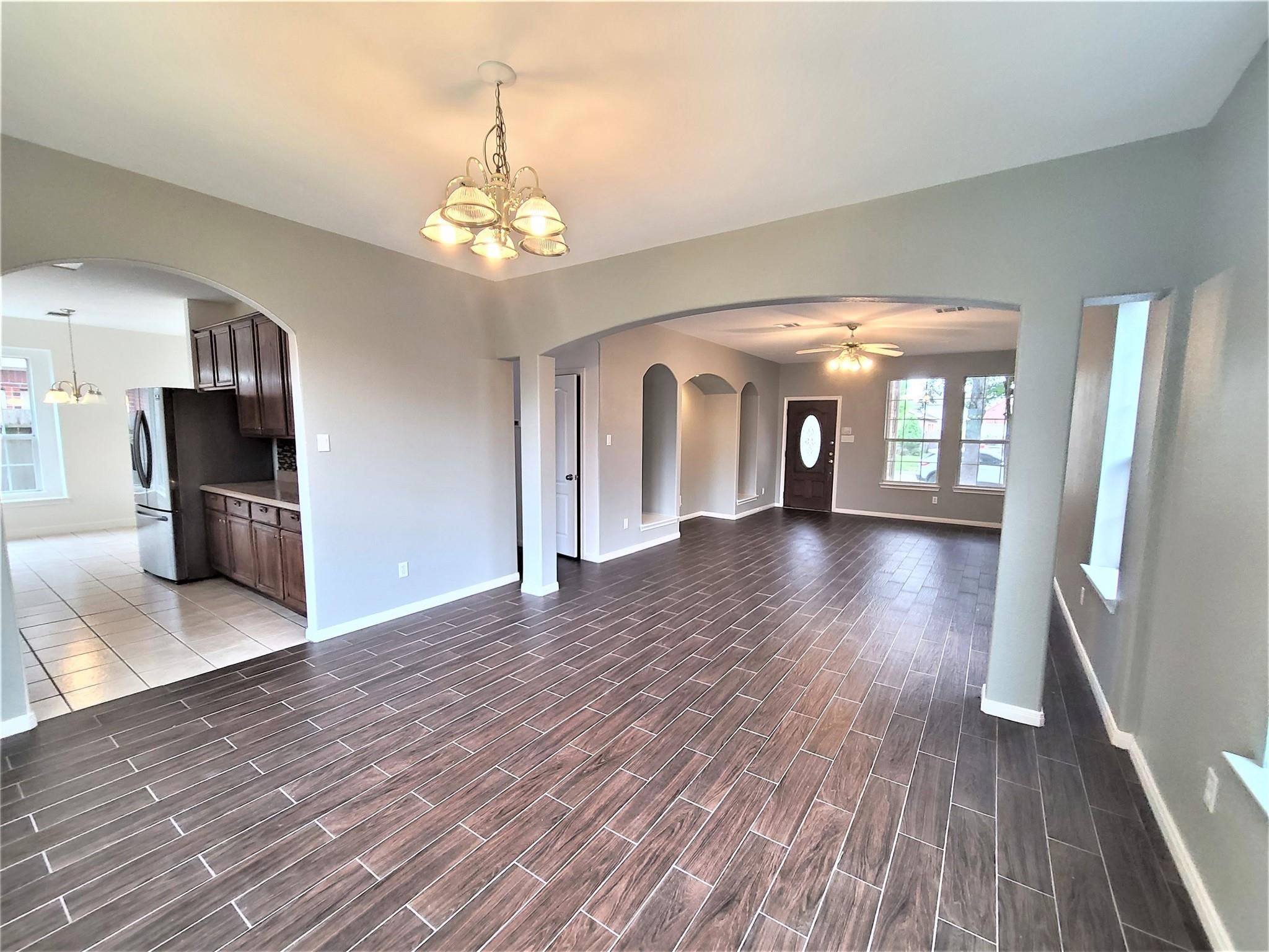10026 Gil Jr Lane Houston, TX 77075 - Photo 4 of 14 a view of a hallway with wooden floor and a kitchen